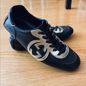 Gucci black with gold accent sneakers.